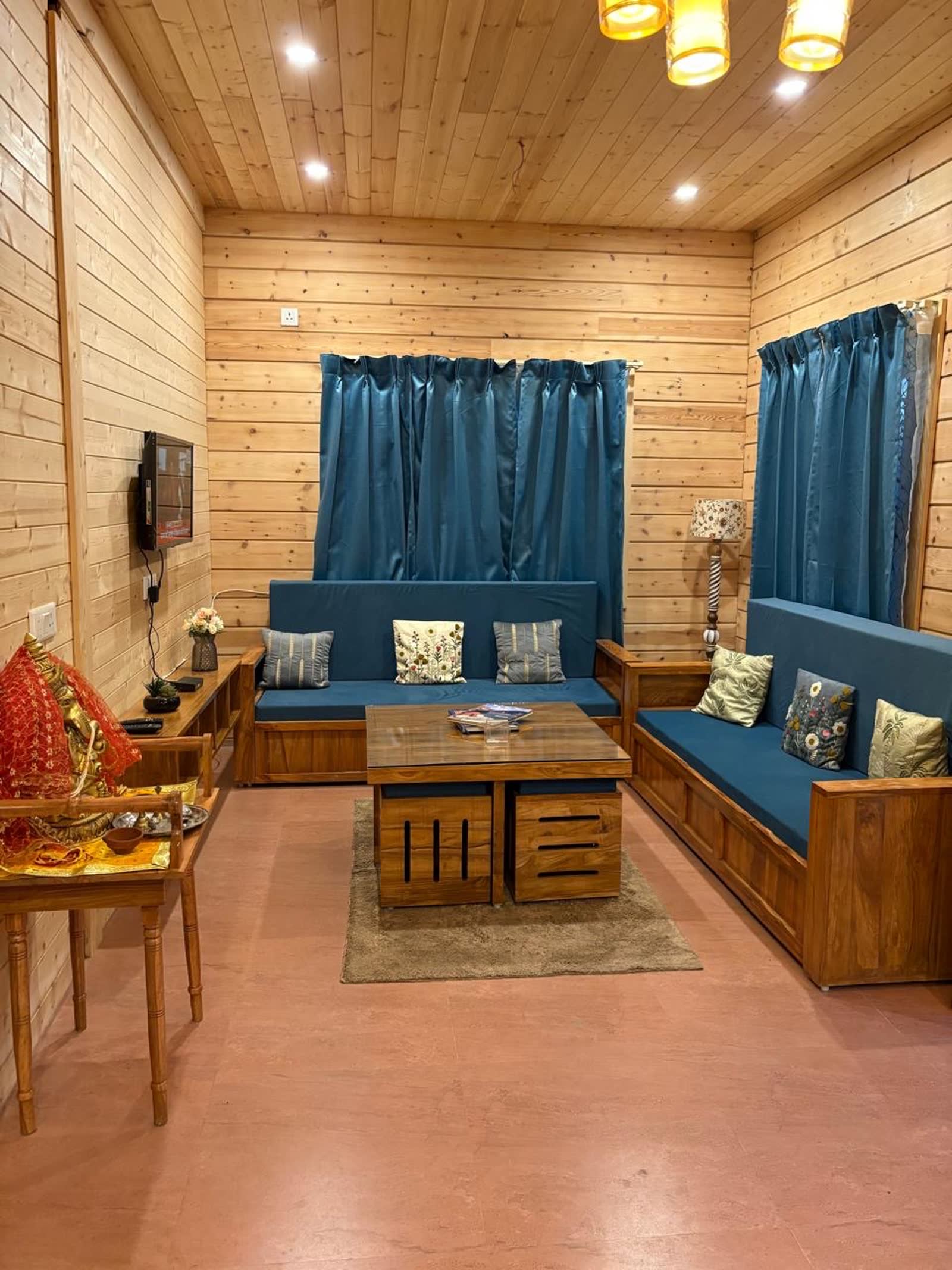 Pine-walled living room with blue sofas and warm chandelier light